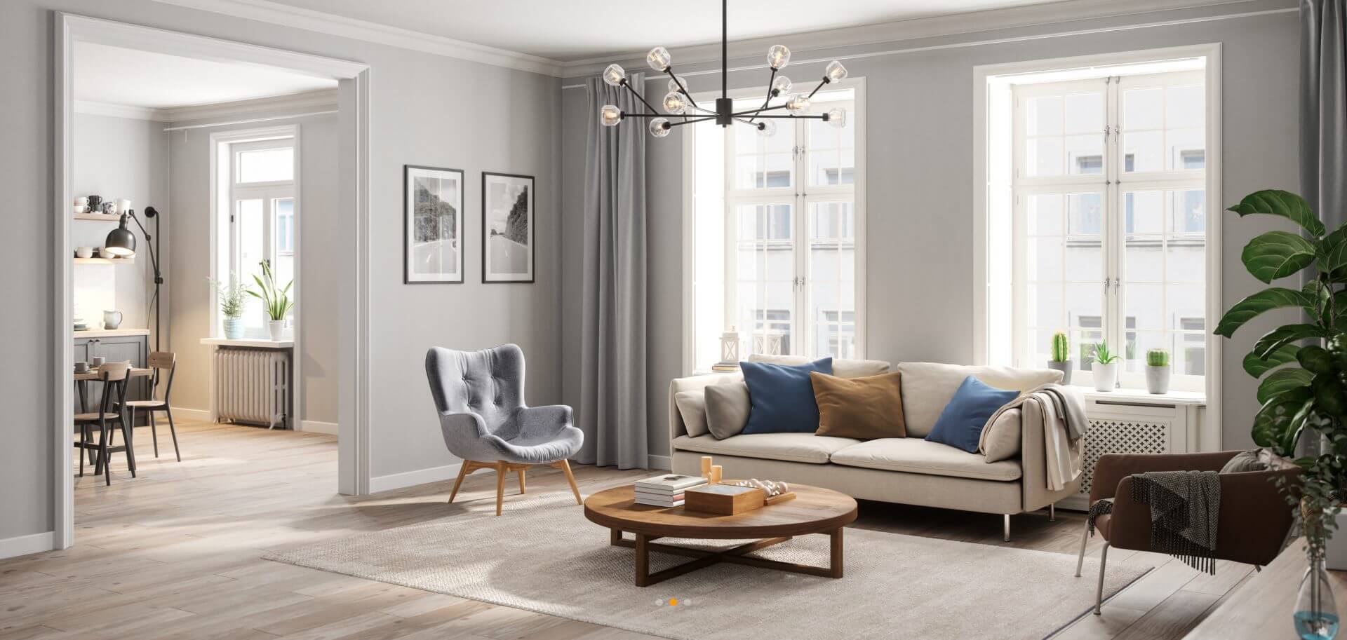 Modern living room with a beige sofa, blue and brown cushions, a wooden coffee table, and a gray chair. Large windows, a chandelier, and an adjacent dining area are visible.