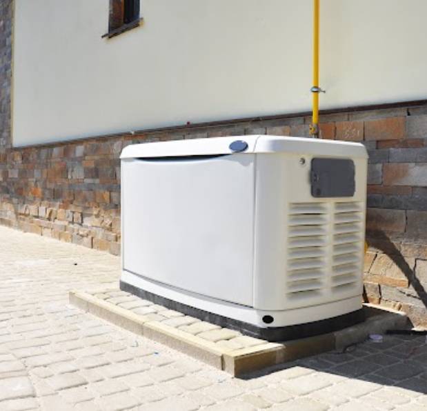 Outdoor backup generator next to brick wall.